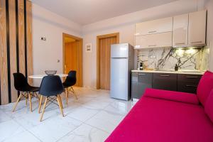 a kitchen with a red couch and a table with chairs at Meli Boutique Hotel in Limenaria