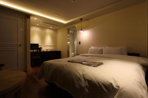 a bedroom with a large white bed in a room at Christie Hotel 크리스티 호텔 in Seoul