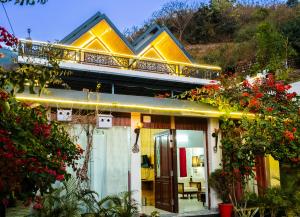a yellow house with a balcony on top of it at The Bougainvillea Retreat in Dehradun