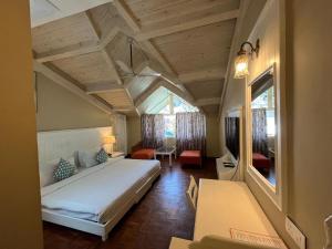 a bedroom with a large white bed in a room at Johnson Lodge Manali in Manāli
