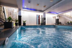 a large swimming pool with blue water in a building at The Bougainvillea Retreat in Dehradun