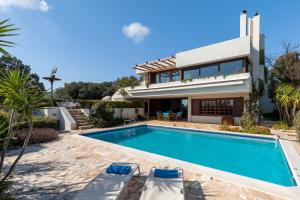 a villa with a swimming pool and a house at Villa KATHERINA G in Schinias