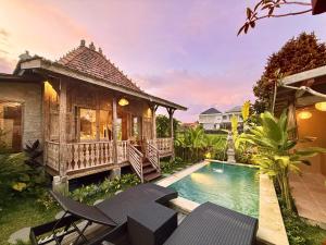 a villa with a swimming pool and a house at Sunshine dijoglo villa in Ubud