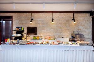 a table with plates of food on it in a kitchen at Acapulco Hotel in Ploieşti