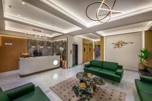 a lobby with green furniture and a reception desk at Lords Studio Inn, Jamnagar in Jamnagar
