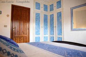 a bedroom with a bed and a door and a window at Casa Lucia vicino al mare in Budoni