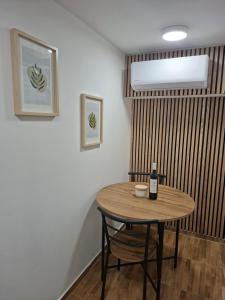 a table in a room with a bottle of wine at Studio apartman Aria in Đakovo +13 photos