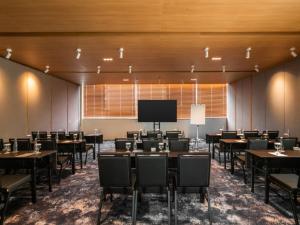 a conference room with tables and chairs and a large screen at ARTOTEL Leguna Magelang in Magelang +37 photos
