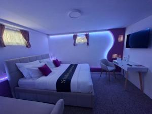 a hotel room with a bed and a desk and a tv at Studio apartman Aria in Đakovo