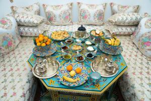 a table with plates and bowls of fruit on a couch at Dar Fayrouz in Fez +46 photos