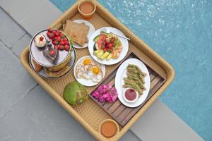 a tray with plates of food on a table at Kaizen Eirene Luxe Villas, Udaipur in Nāi