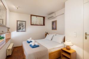 a small bedroom with a bed with towels on it at Villa KATHERINA G in Schinias +29 photos