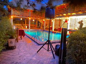 a camera on a tripod next to a pool at night at Elite Backpackers Services in Masaka