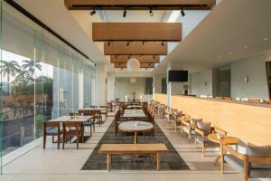 a restaurant with tables and chairs and a large window at ARTOTEL Leguna Magelang in Magelang