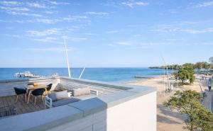 a balcony with a table and chairs and the beach at Ostsee Suite 2 - Penthouse in Niendorf
