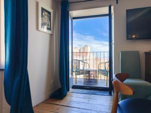 a room with a sliding glass door with a balcony at La Tour Grégoire in Clermont-Ferrand