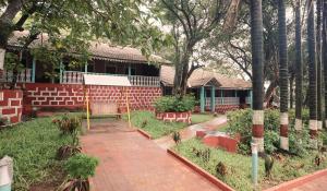 a garden in front of a house with a brick sidewalk at The Byke Retreat Brightland - Pan India Pure Veg Hotel Chain in Matheran