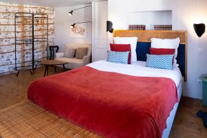 a bedroom with a large bed with red and blue pillows at La Tour Grégoire in Clermont-Ferrand