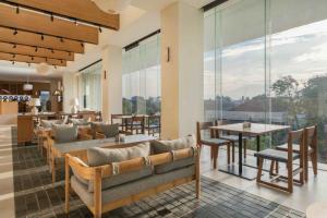 a restaurant with chairs and tables and large windows at ARTOTEL Leguna Magelang in Magelang