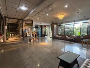 a lobby with couches and a table in a building at โรงแรมวินบางนา Win Bangna Hotel in Bangna