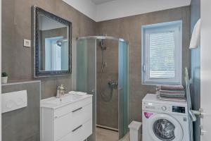 a bathroom with a shower and a washing machine at House Degenia in Lovinac