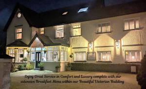 a large house is lit up at night at Brigstock House in Llandudno