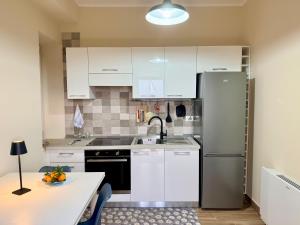 a kitchen with white cabinets and a refrigerator at Al vico1 in Campo Calabro