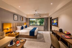 a hotel room with a bed and a desk at Lords Studio Inn, Jamnagar in Jamnagar +53 photos
