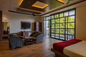 a hotel room with a bed and a living room at Flying Sparrow Riverside Resort in Dhikuli