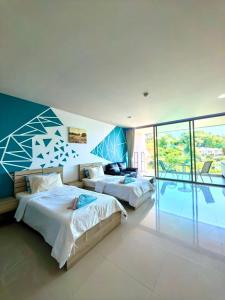 a bedroom with two beds and a balcony at Veloche Karon 12 in Karon Beach