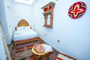 a small bedroom with a bed and a table at Dar Fayrouz in Fez