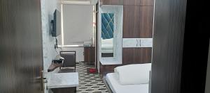 a bathroom with a mirror and a bed and a sink at Hotel Laxmi villa in Naini +26 photos