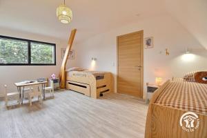 a bedroom with two beds and a table and a desk at Les maisons de l'if - le cottage in Pluméliau +40 photos