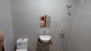 a bathroom with a sink and a toilet at Hotel Kaushik Palace in Haridwār