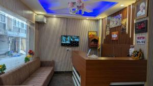 a lobby with a reception desk with a blue ceiling at Hotel Kaushik Palace in Haridwār +18 photos