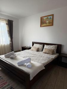 a bedroom with a bed with two towels on it at Complex Turistic Brândușa in Avrig