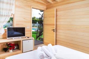 a room with a tv and a bed and a window at Müptela Alaçatı in Çeşme