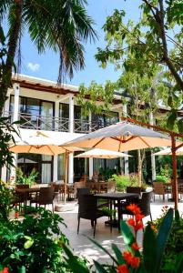 a patio with tables and umbrellas in front of a building at Golden view hotel Tanzania in Dar es Salaam