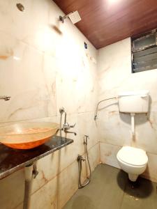 a bathroom with a sink and a toilet at Hotel Orange Inn in Koparpāda +5 photos