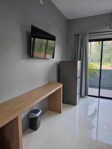 a kitchen with a desk and a refrigerator in a room at Luangwang Resort in Nai Yang Beach