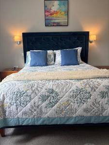 a bedroom with a large bed with blue pillows at Were House Warminster in Warminster