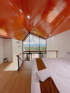 a bedroom with a bed and a large window at Villa with jacuzzi, Damar Ningrum 5 in Panjadakan