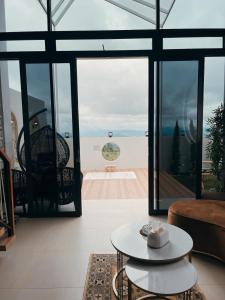 a living room with large windows and a view of the ocean at Villa with jacuzzi, Damar Ningrum 5 in Panjadakan