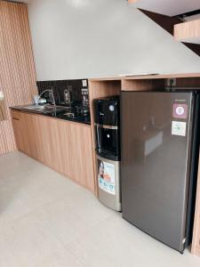 a kitchen with a black refrigerator and a sink at Villa with jacuzzi, Damar Ningrum 5 in Panjadakan