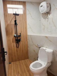 a bathroom with a toilet with a camera on the wall at Villa with jacuzzi, Damar Ningrum 5 in Panjadakan +13 photos