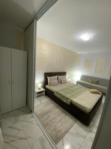 a bedroom with a bed and a sliding glass door at Lemora Apartments 1 in Focşani