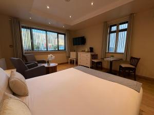 a bedroom with a white bed and a living room at Feeney's Audubon Lodge in Galway
