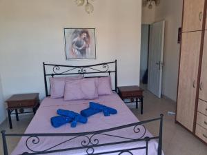 a bedroom with a bed with blue bows on it at Big Terrace 180 view to sea in Akritokhórion