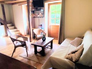a living room with a couch and chairs and a table at L'âne à plumes in Coisia