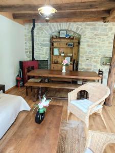 a room with a wooden table and a table and chairs at L'âne à plumes in Coisia +34 photos